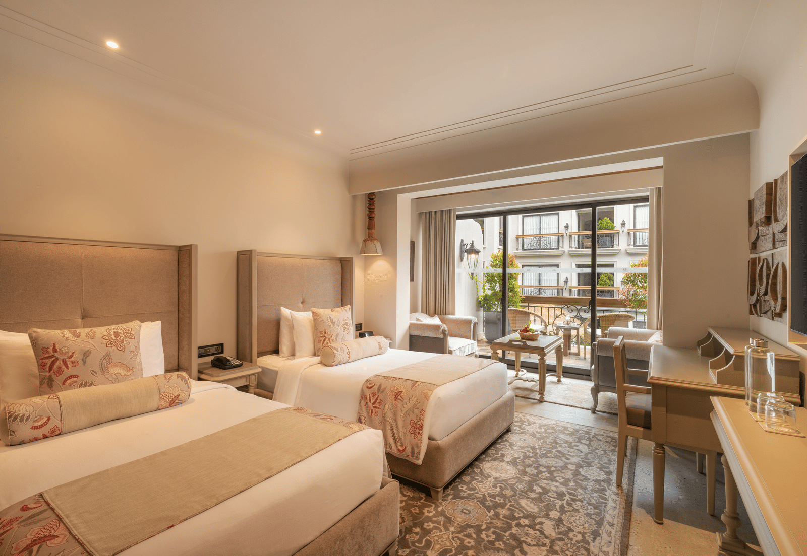 Corner view of the Premium Room with with beds at The Evren, Vagator, with ample of natural light coming from the french windows.