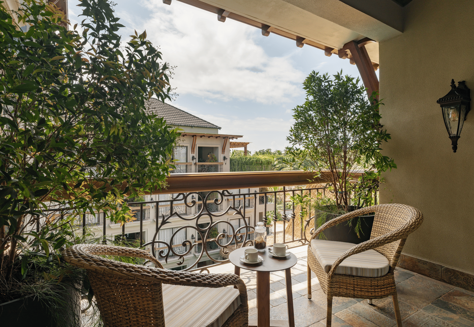 A beautiful balcony with an outdoor seating area overlooking the building opposite to it from the Premium Room at The Evren, Vagator.