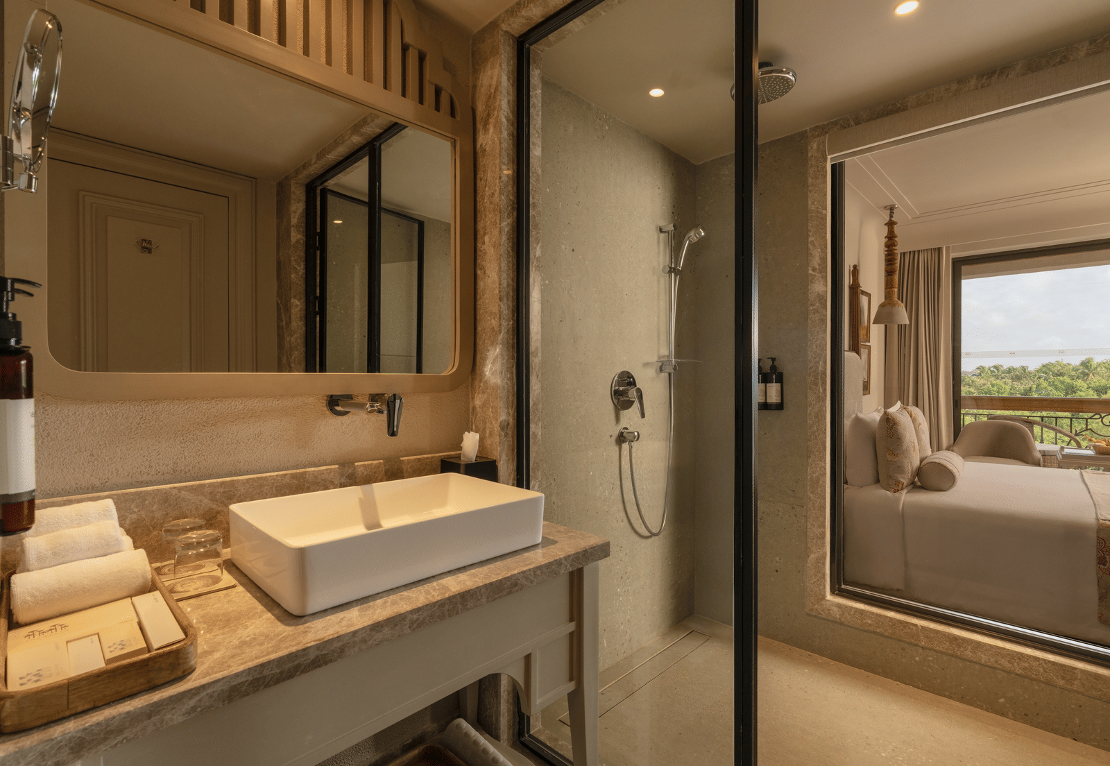 A neatly-kept vanity area with a rectangular mirror above it at the Classic Room (Diwa), seaprated by a glass partition at The Evren, Vagator.