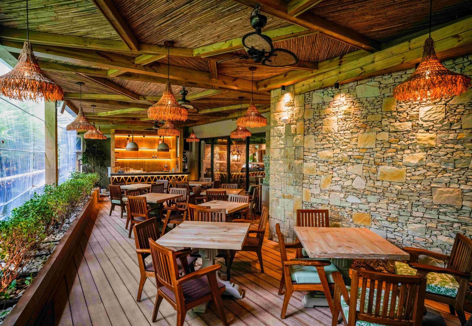 A wide-angle shot of the interiors of the Mila restaurant brightly-lit from the natural light coming from the windows at The Evren, Vagator.