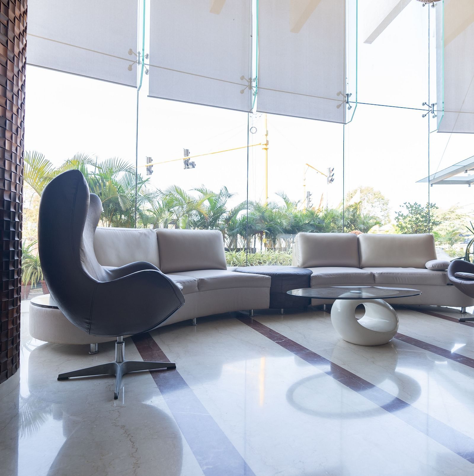 waiting area with a lounge, chairs and a round table at The President Hotel, Hubli