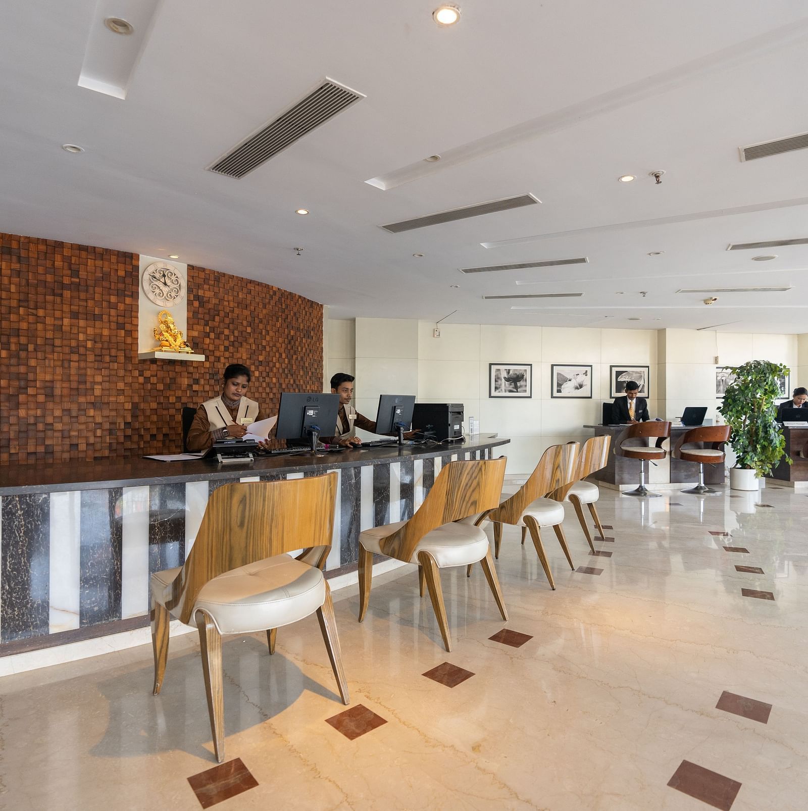 An image showcasing the hotel reception area of The President Hotel, Hubli with people working