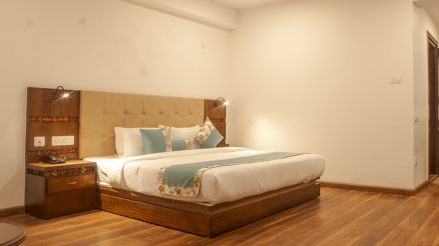 Spacious bedroom at Voyage Glenz Resort featuring wooden flooring, contemporary furnishings, and a cosy ambiance.