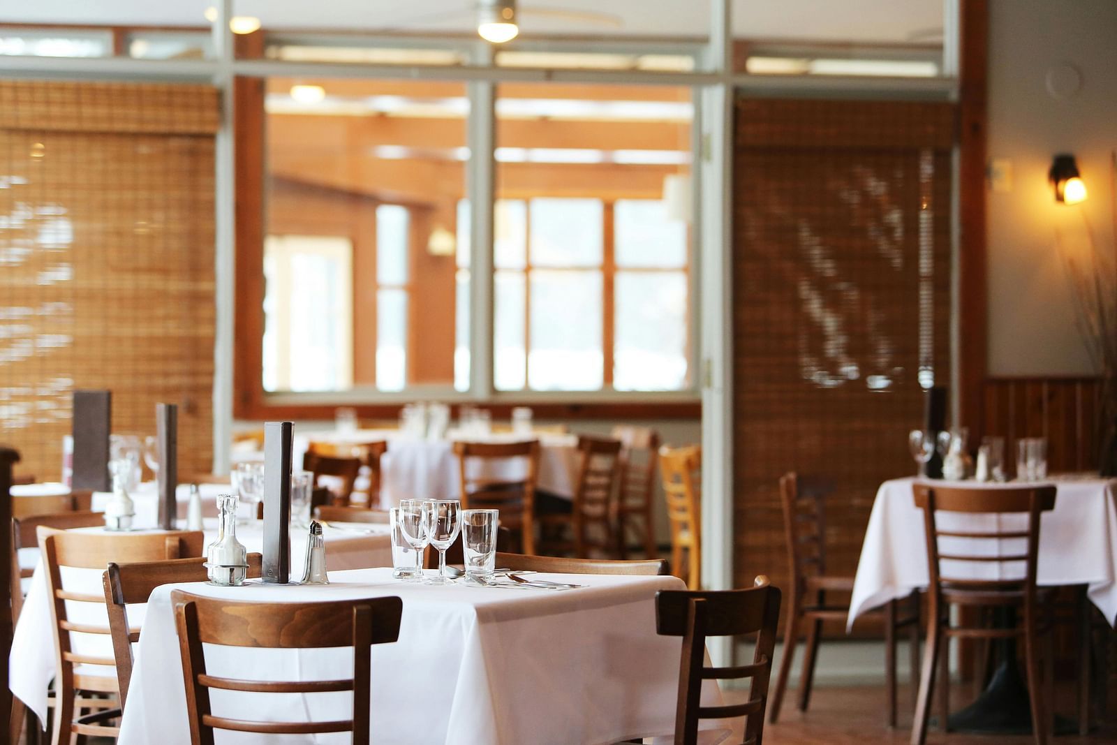 Dining area with tables set with cutlery and chairs arranged for the guests.