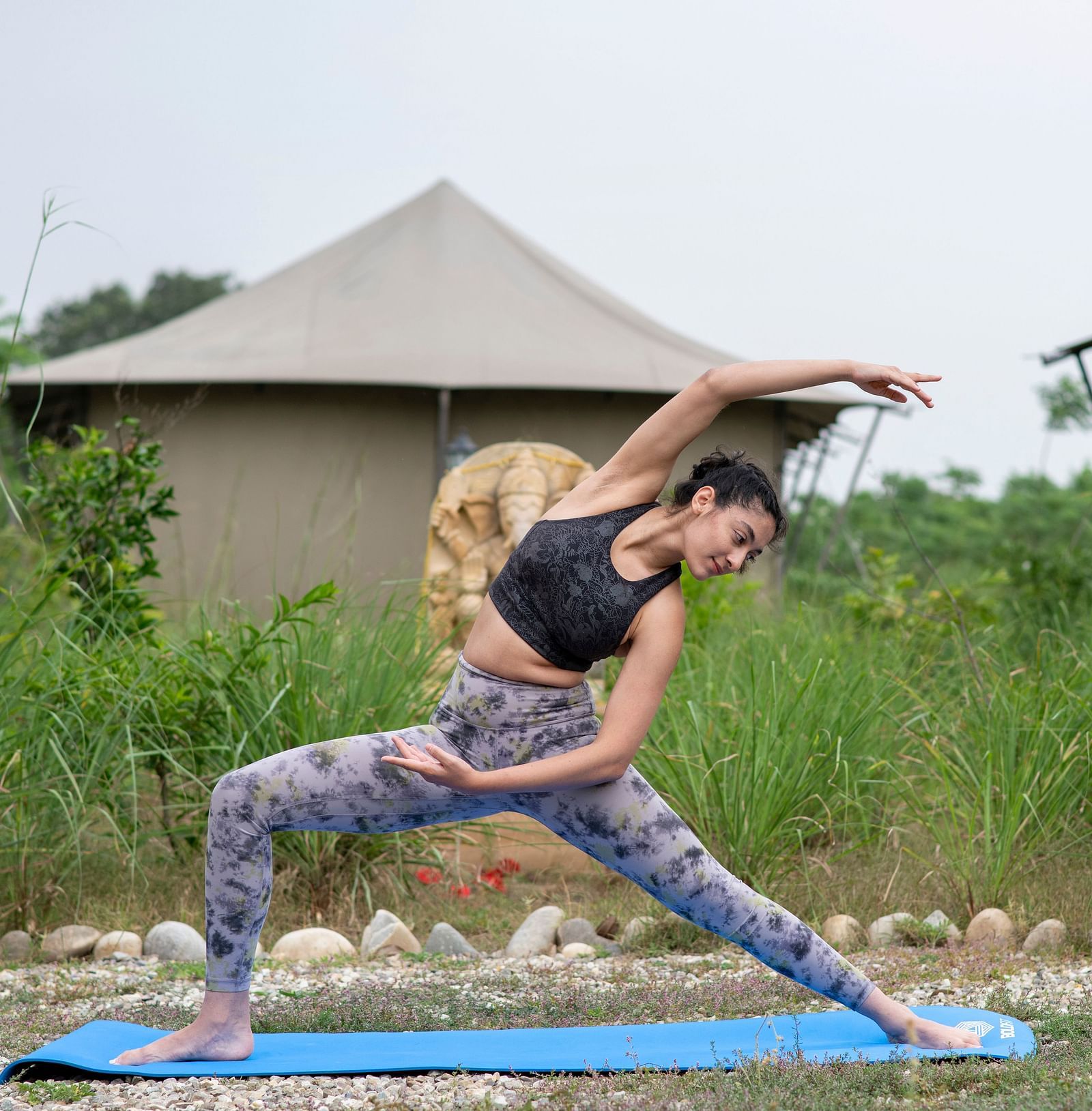 A woman doing yoga in front of tent near Haridwar - Aalia Jungle Resort & Spa