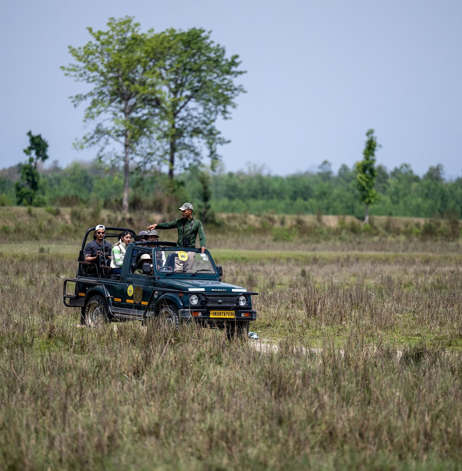 A car driving through dry grass lands during a safari at Rajaji National Park - Aalia Jungle Resort & Spa