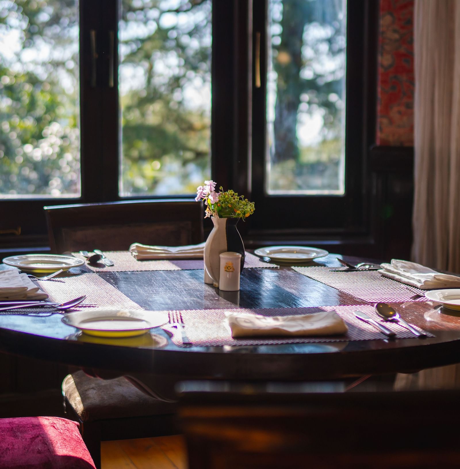 A dining space with chairs, large windows overlooking a forest and a table adorned with various snacks - The Claridges Nabha Residence, Mussoorie