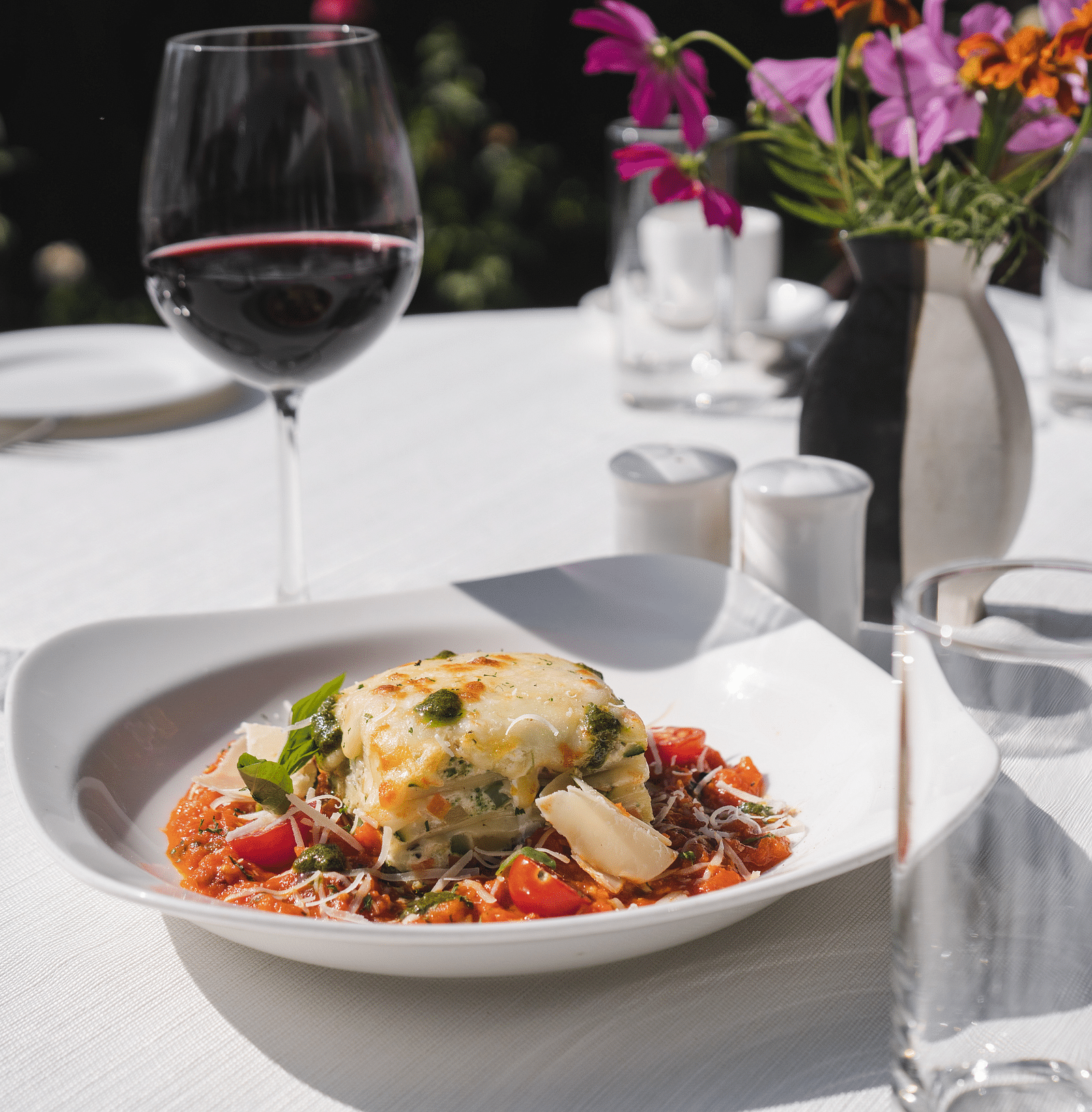 image of lasagne served with a glass of wine at The Claridges Nabha Residence