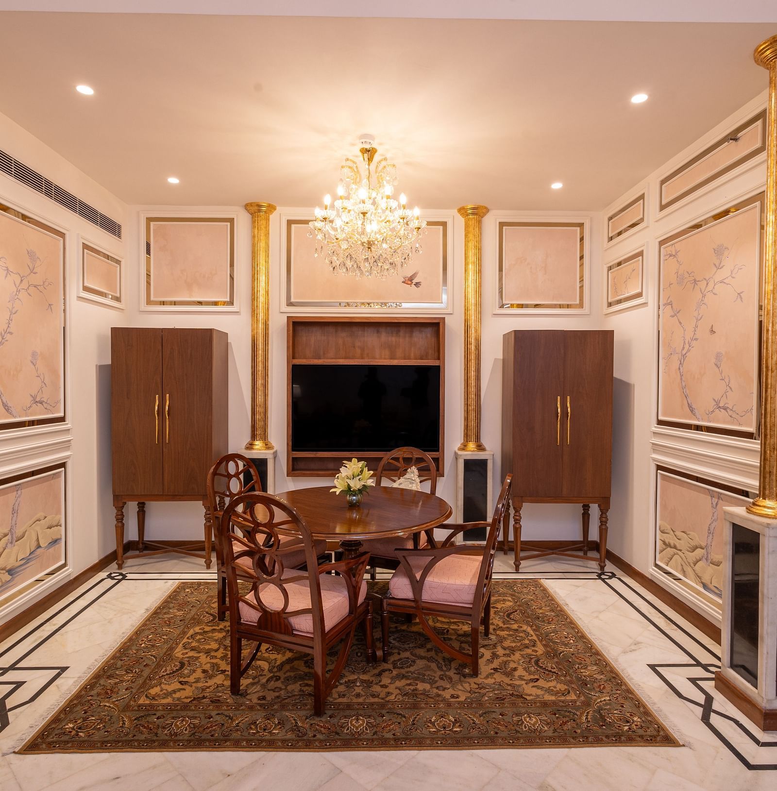 Luxury Suite at The Claridges New Delhi, showcasing a corner view of the room with a stylish dining table and an elegant chandelier hanging overhead