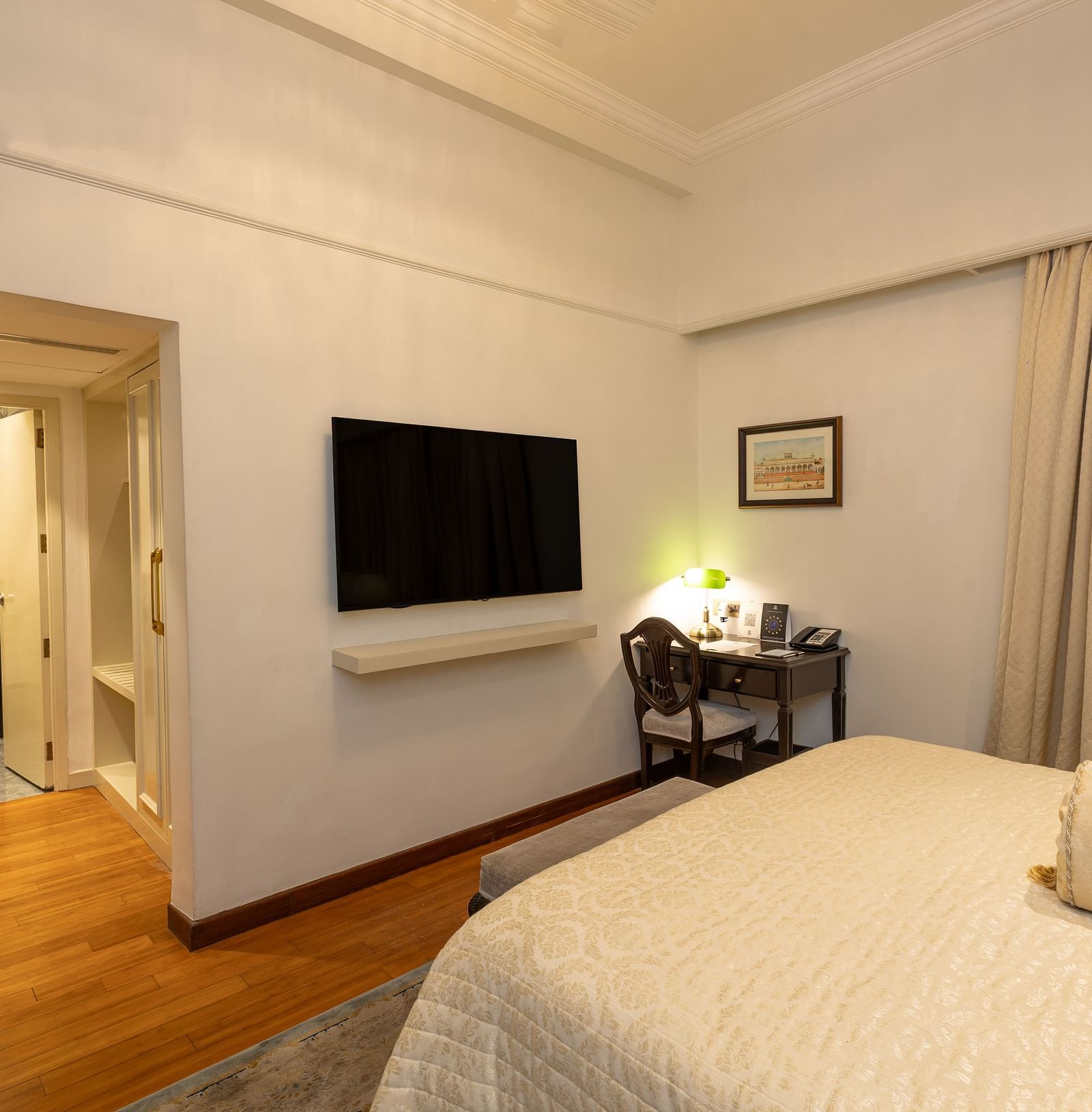 Superior King Bed Room at The Claridges New Delhi, featuring a wall-mounted TV and an entryway leading to the wardrobe area