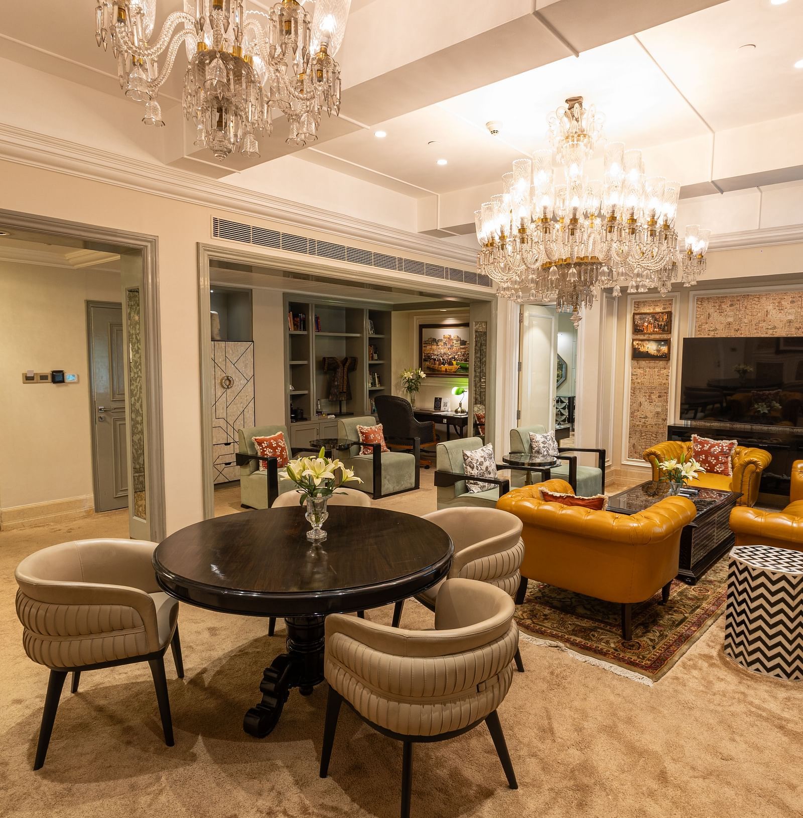 Presidential Suite at The Claridges New Delhi, featuring a spacious area with a cosy couch and a chandelier hanging overhead