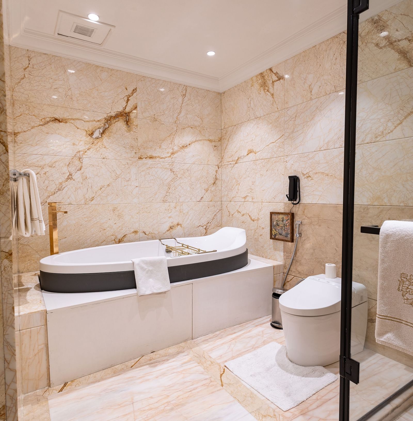 Presidential Suite washroom at The Claridges New Delhi, featuring a luxurious bathtub and a glass-enclosed bath area