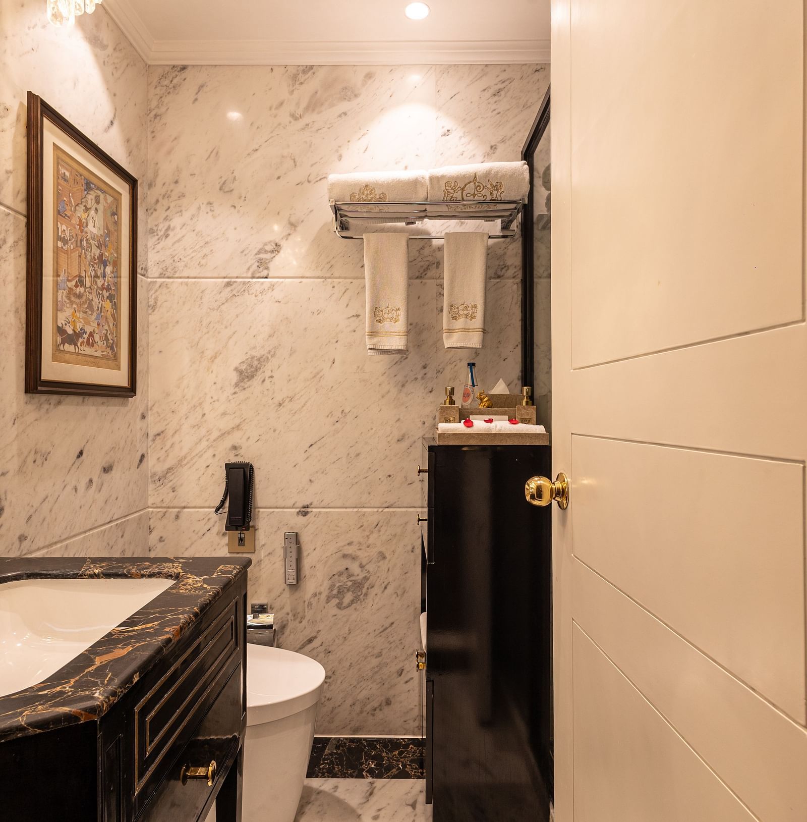 Washroom of the Luxury Twin Bed Room with Balcony at The Claridges New Delhi, featuring a modern sink and a stylish wall-mounted mirror