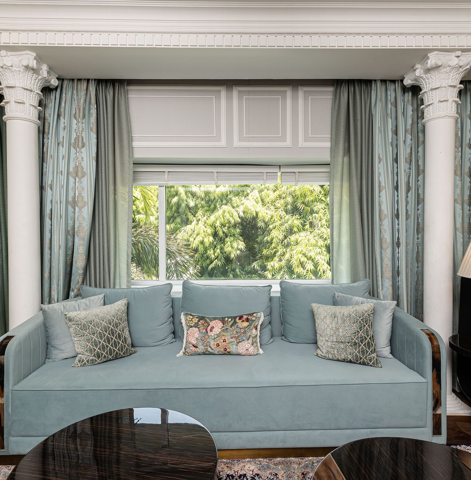 An image of a blue couch with lamps placed on either side of it at the Diplomatic suite room - The Claridges New Delhi