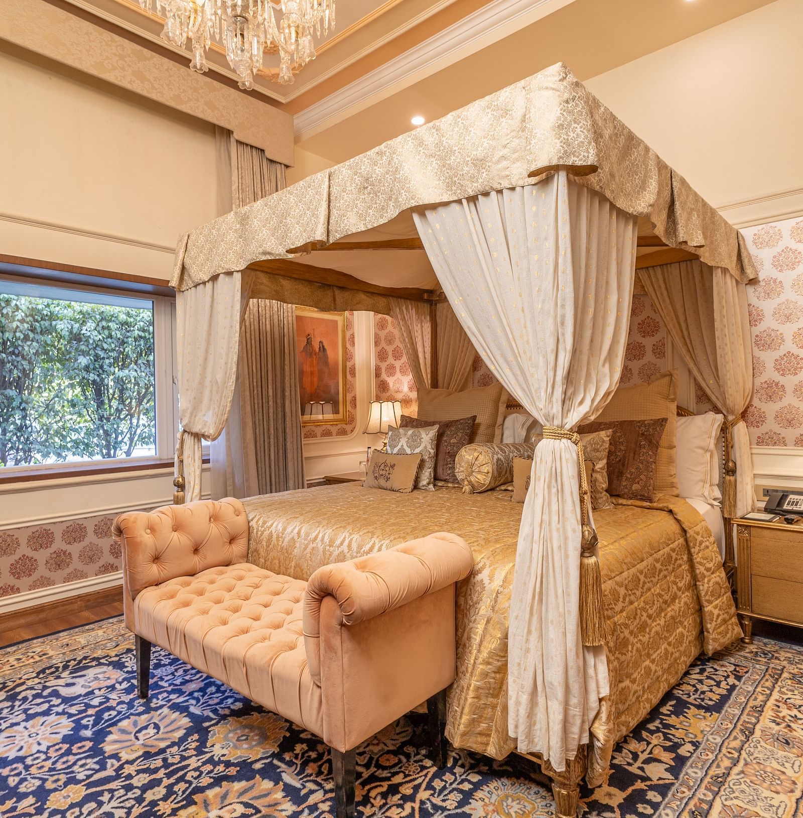image of the bedroom with a king size bed and thick curtain drapes around the bed giving a royal touch at our heritage parlour suite - The Claridges New Delhi