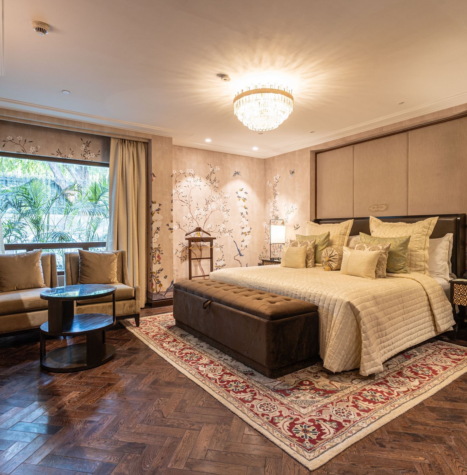 image of the bedroom of the cabana room featuring a modern interior with grey themed colour tone - Image of the Cabana Room featuring two single-seater couches and a wall-mounted television - The Claridges New Delhi