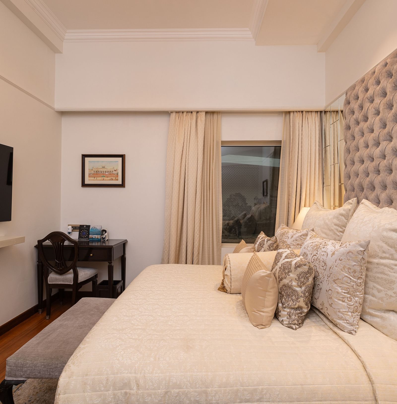 image of a king size bed with well set pillows over at our boutique room with a wall mounted tv - The Claridges New Delhi
