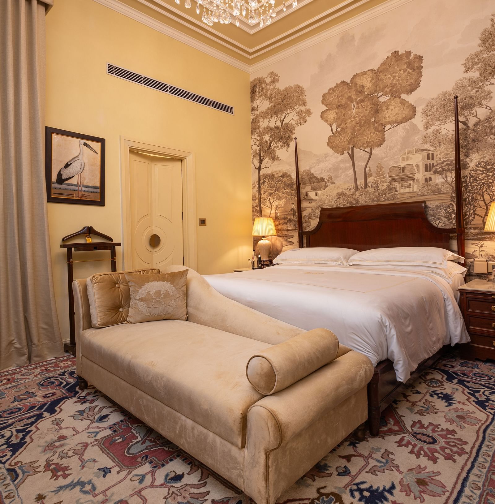 image of a bedroom at our heritage room with a brown scale wallpaper with lush trees - The Claridges New Delhi 