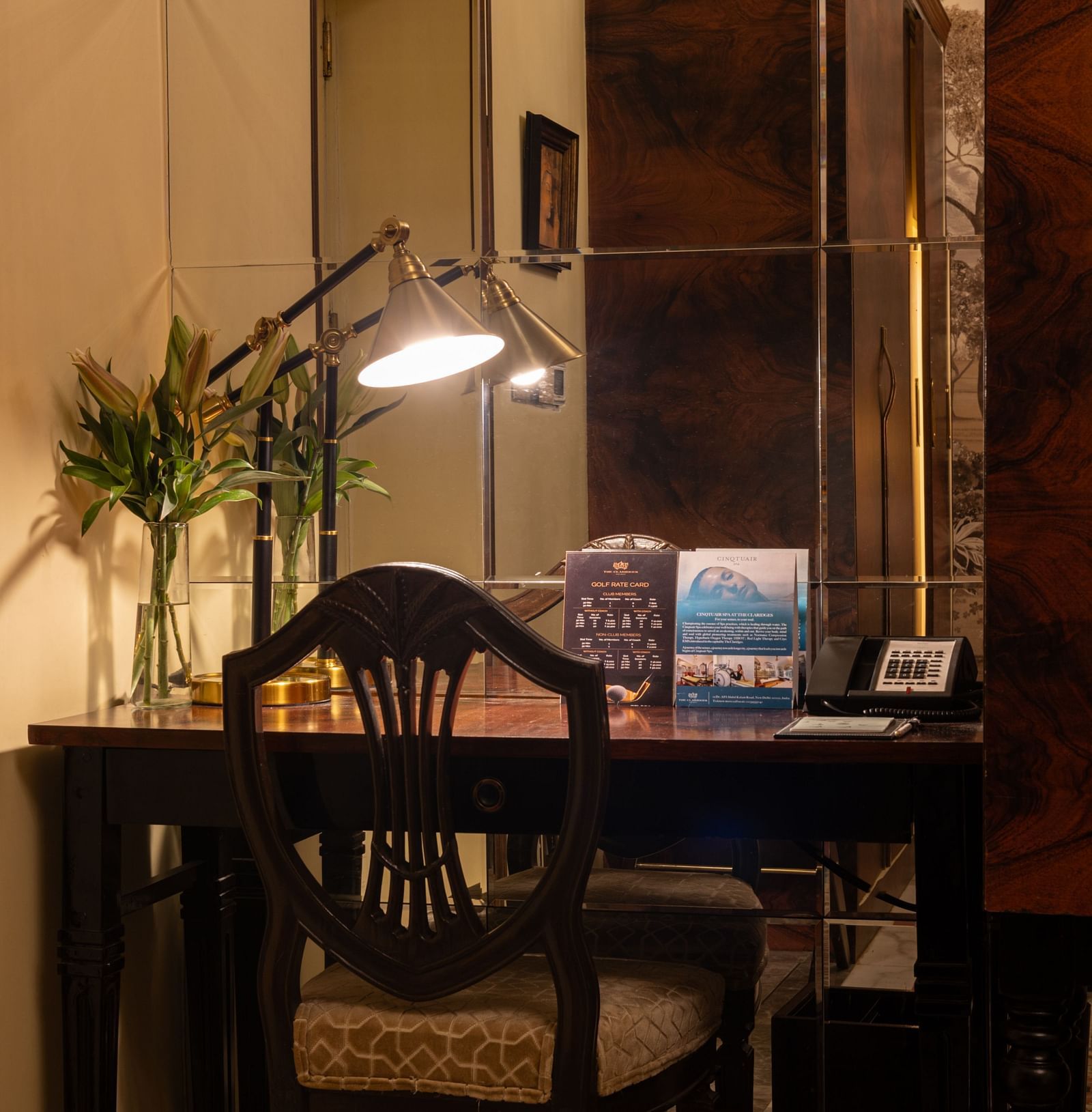 an image of the work desk with a table lamp providing light on the table at our heritage room - The Claridges New Delhi