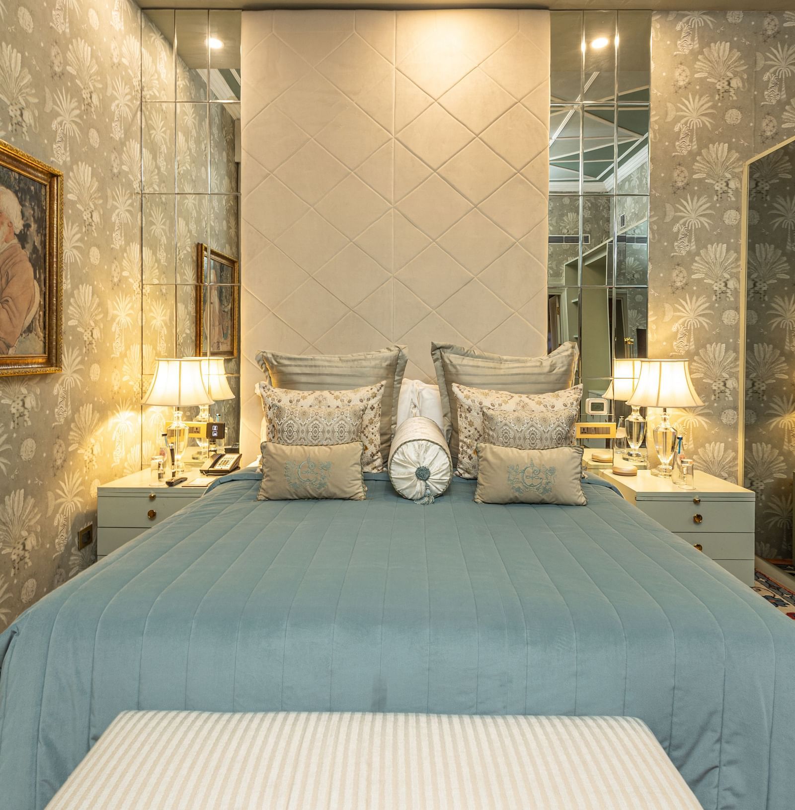 image of a king size bed with a teal blue comforter spread over the bed at our heritage luxury suite - The Claridges New Delhi