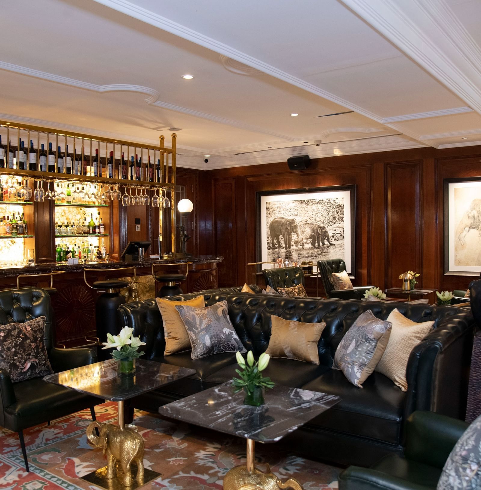 image of the elephant bar with elegant black leather couches at The Claridges New Delhi