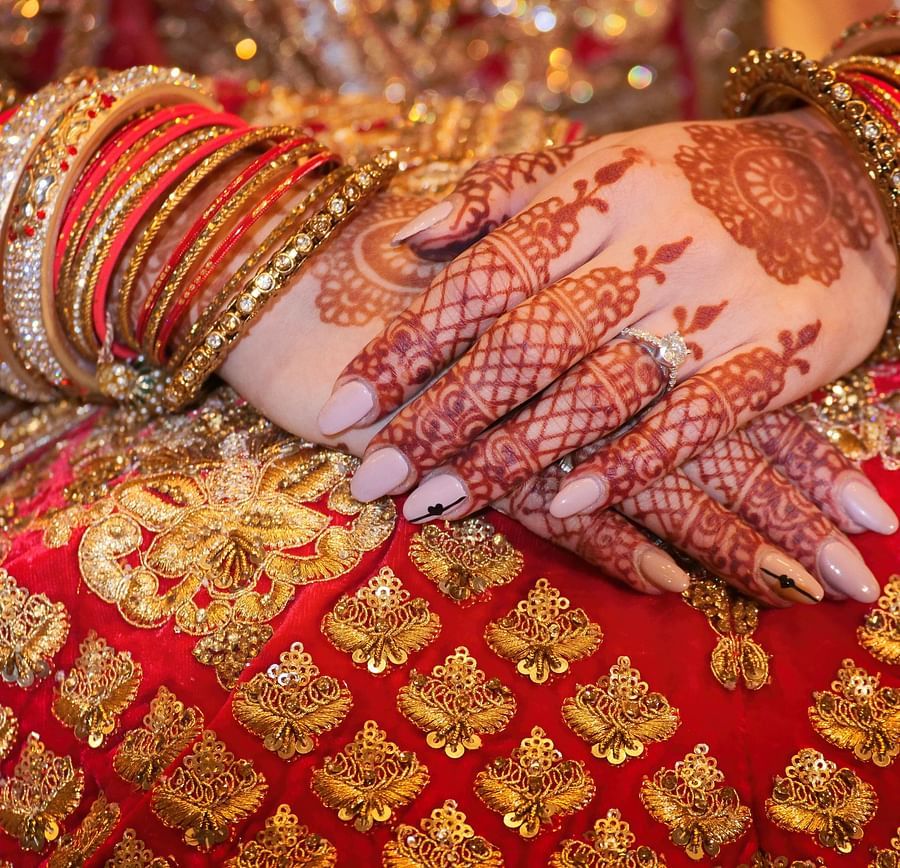 bride sitting in a red bridal attire and jewellery