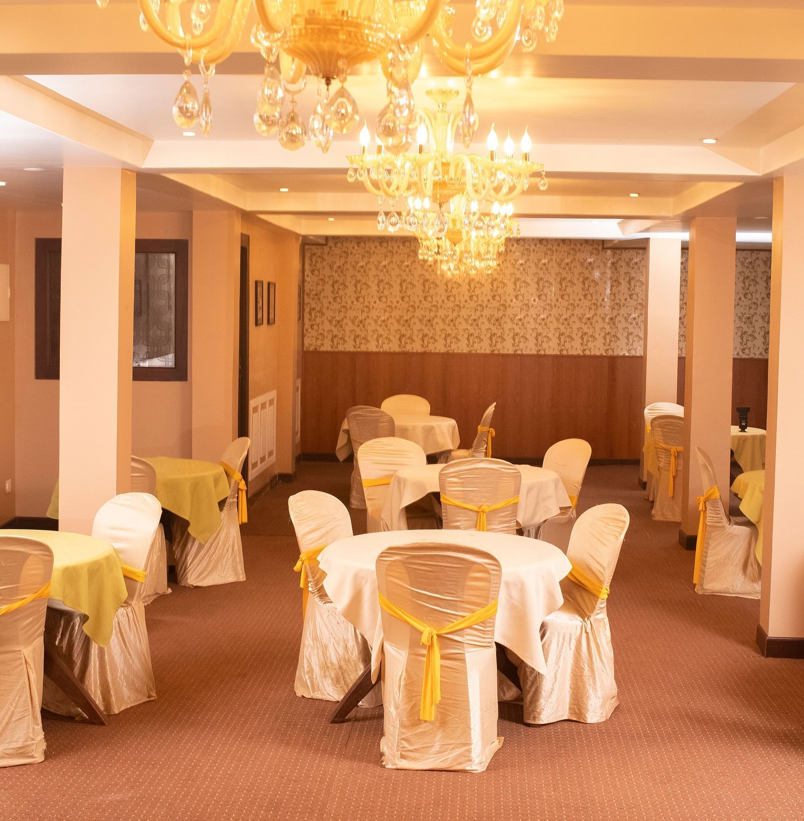 Multiple round tables and chairs placed in a closed hall that has chandeliers | Summit Oakden Resort & Spa, Mall Road