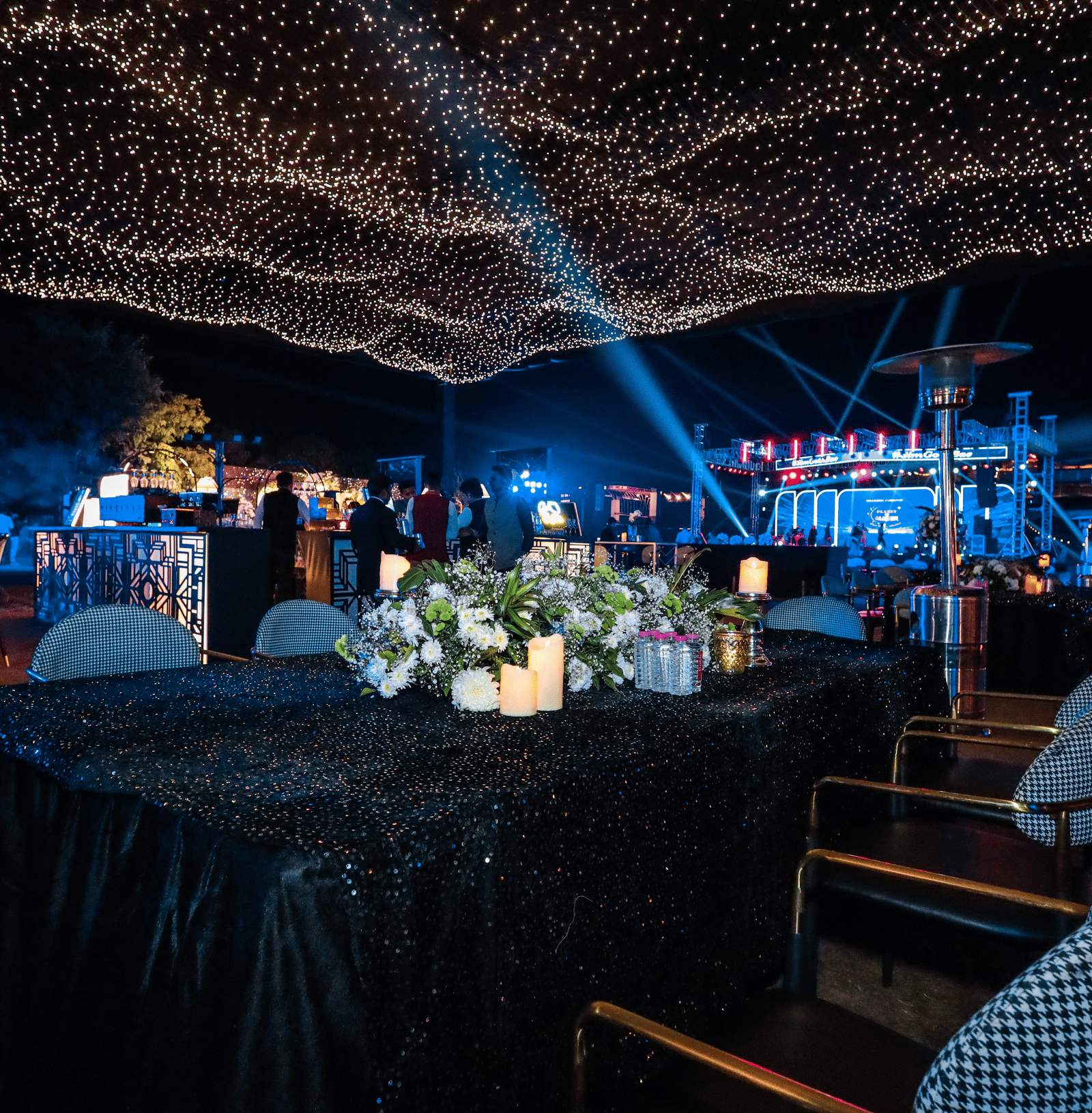 Outdoor dining area with tables under string lights at Ananta Spa and Resorts, Jaipur.