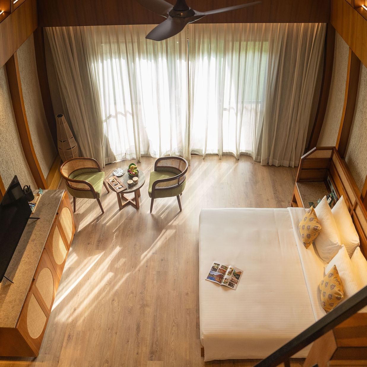A stunning kind size bedroom with high ceilings, seating area, and large windows allowing natural light at Ananta Spa and Resort, Ajabgarh.