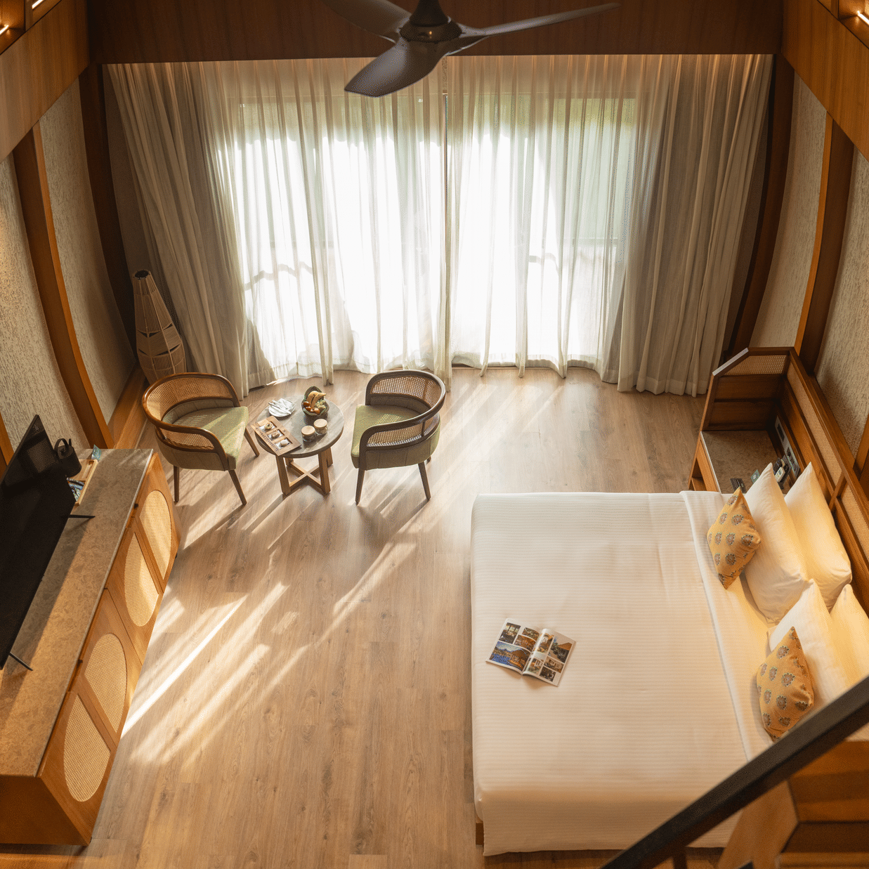 A stunning king size bedroom with high ceilings, seating area, and large windows allowing natural light at Ananta Spa and Resort, Ajabgarh.