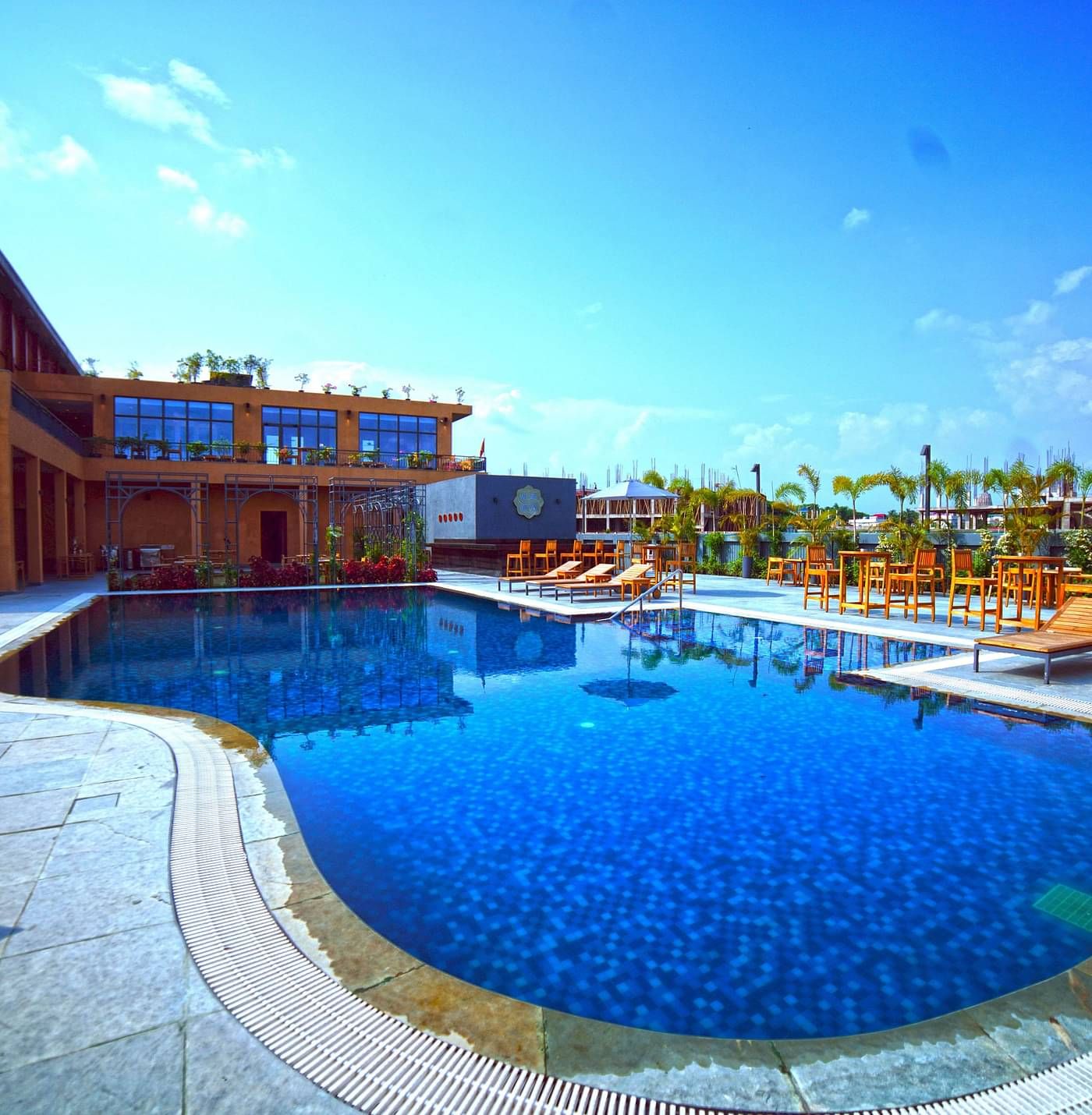 Outdoor swimming pool at Singalila Club with lounging chairs placed around the periphery