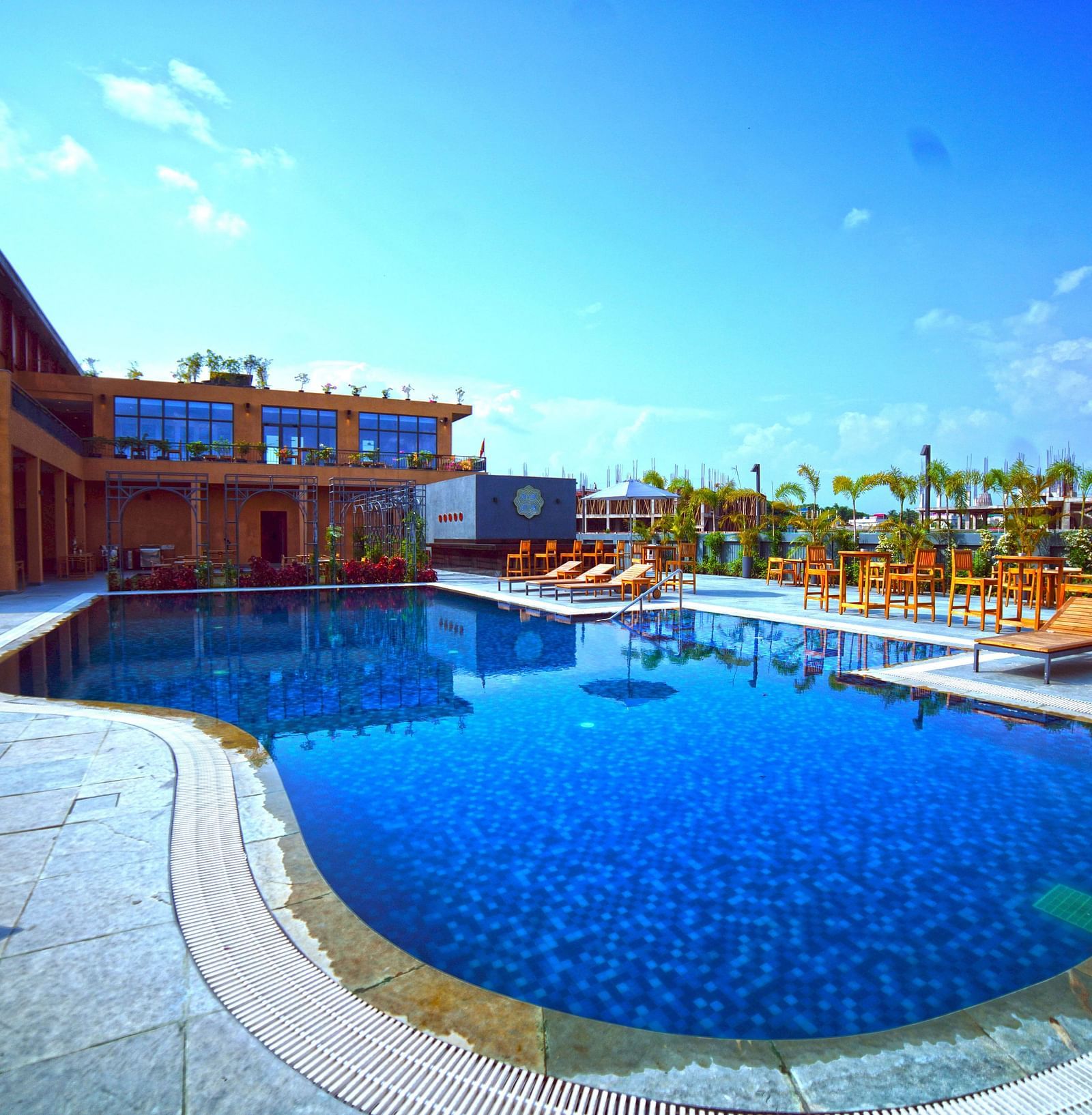 Outdoor swimming pool at Singalila Club with lounging chairs placed around the periphery