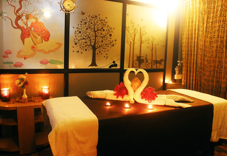 Image of a spa bed with two towel swans on it at Coorg Jungle Camp Backwater Resort, Kushalnagar.