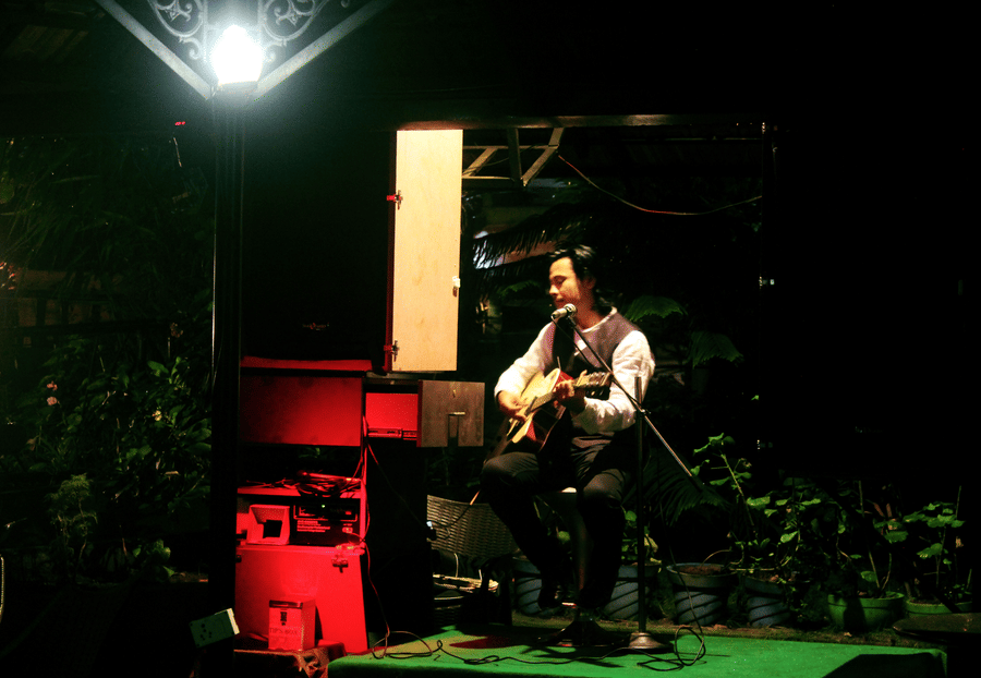 Image of a man playing a guitar at Coorg Jungle Camp Backwater Resort, Kushalnagar.