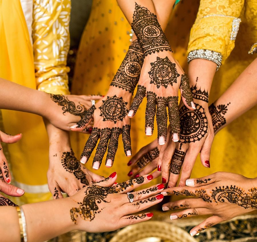 a group of women stretched out their mehendi tainted arms