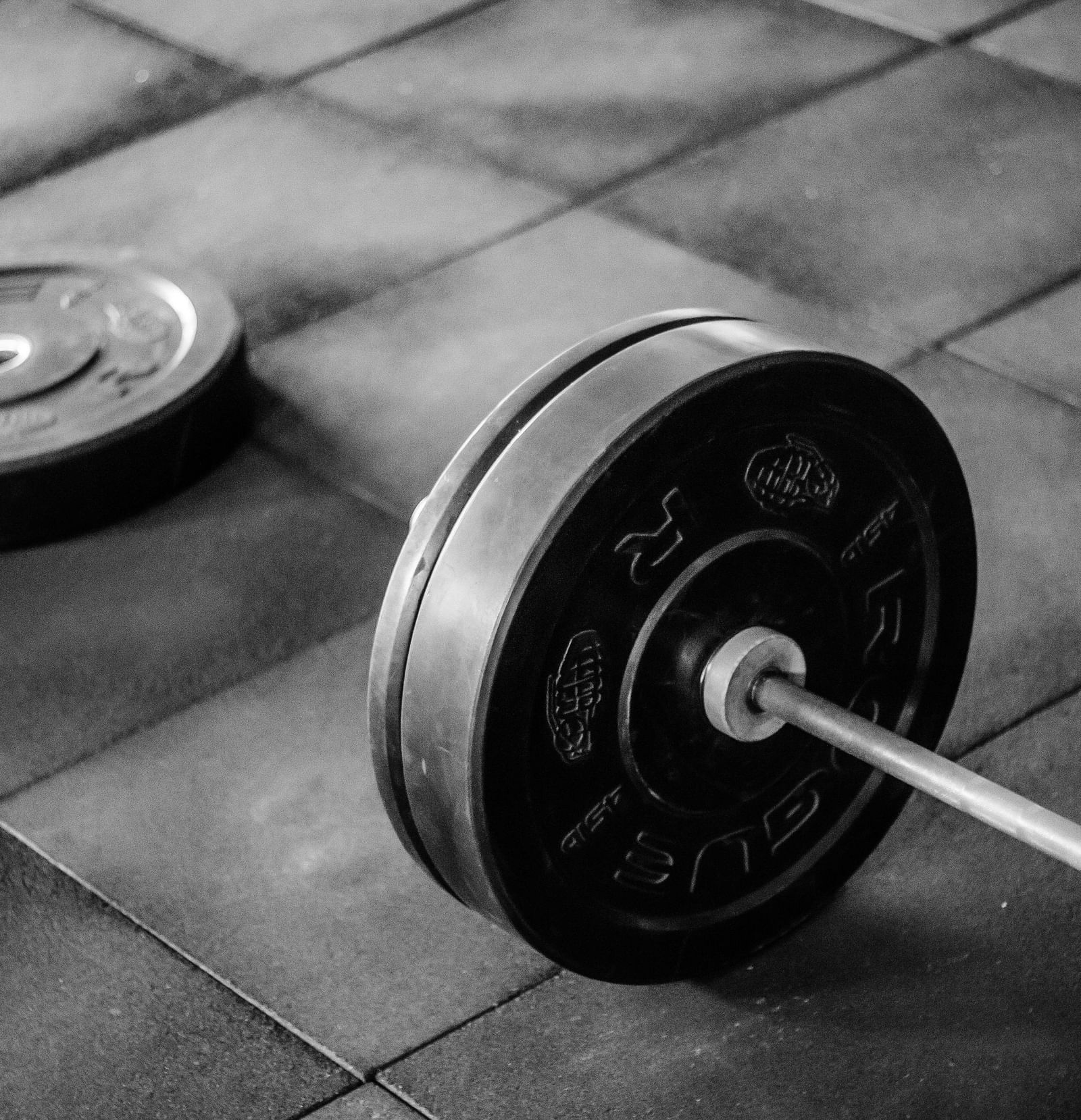 A barbell with free weight plate lying around it