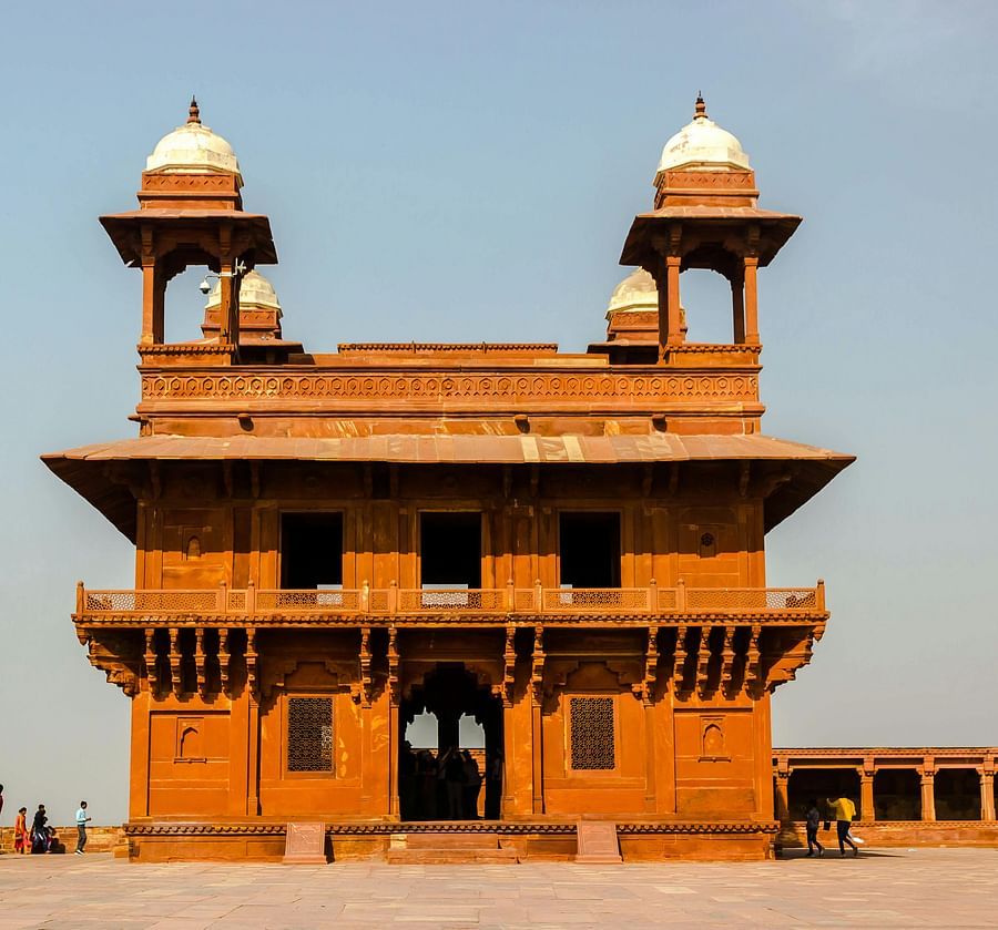 Two-story red sandstone building with domed towers.