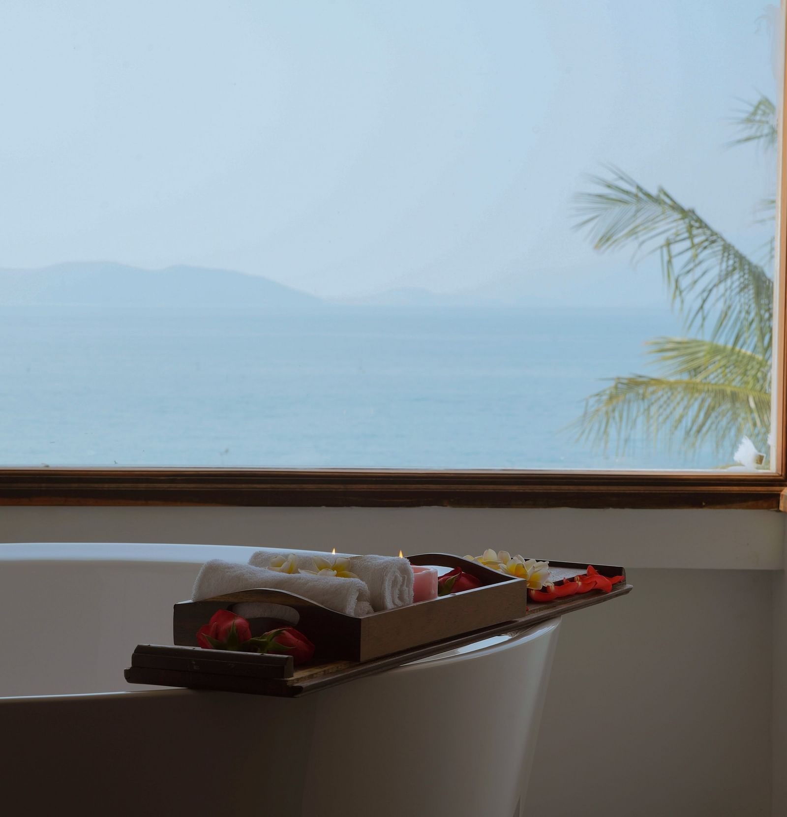 A image of a bathtub near a window overlooking the beautiful landscape - Alibu Resort