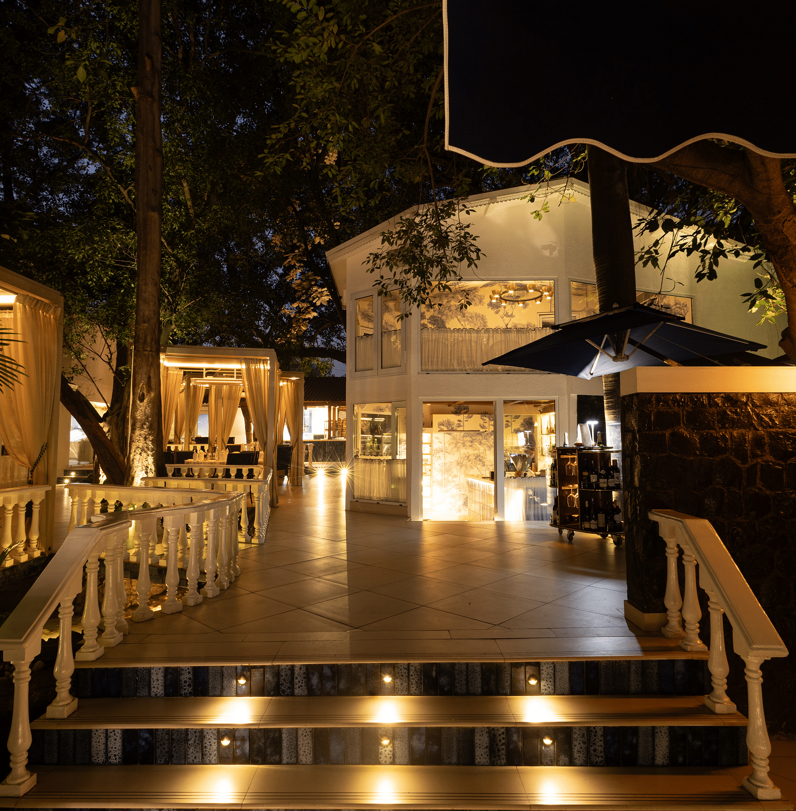 Sevilla restaurant entrance at The Claridges New Delhi, beautifully illuminated at night, showcasing its charming alfresco and indoor dining spaces