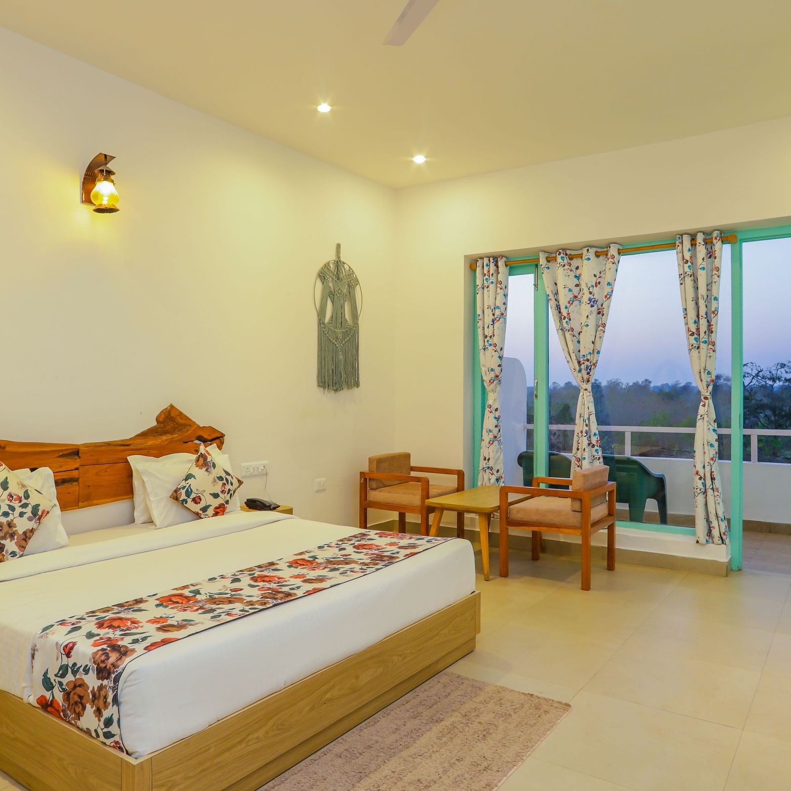 A cosy bedroom at Vedikant Resorts The Mallard Corbett includes a bed, chairs, and a view through the balcony.