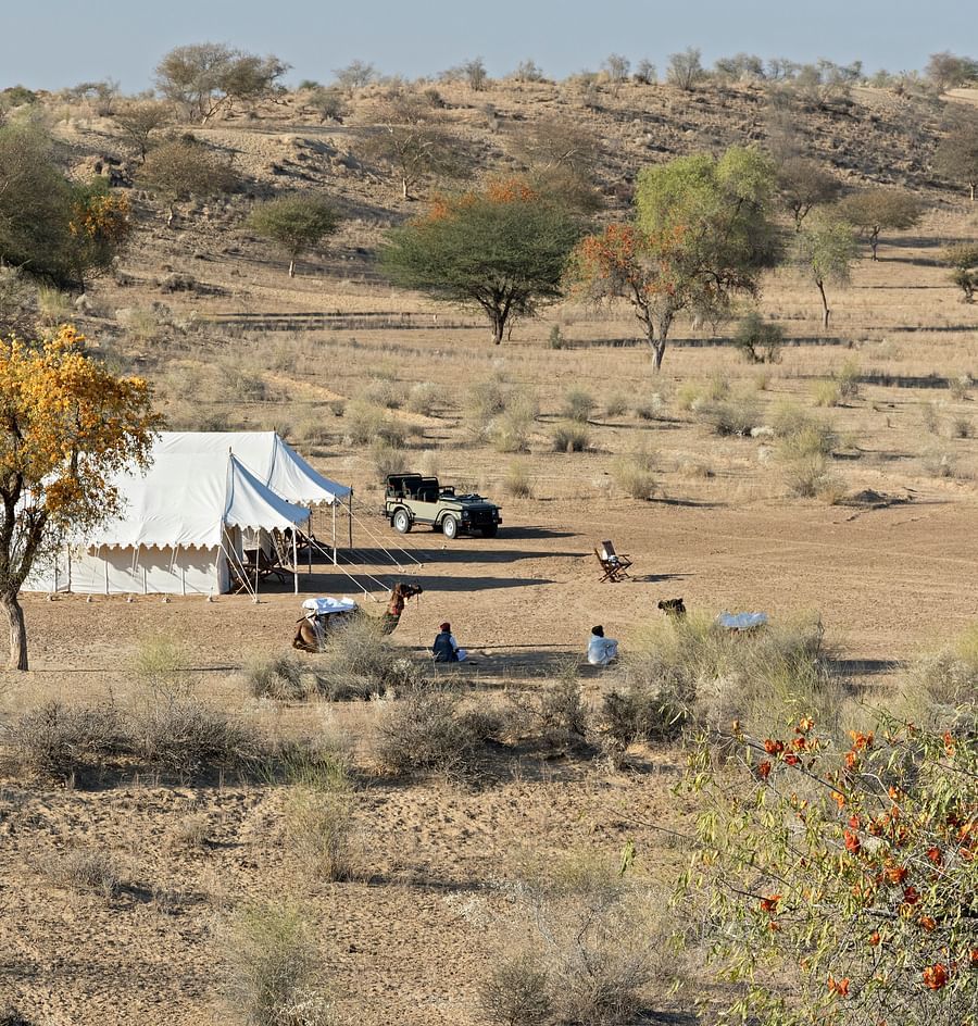 The campsite is seen from a higher altitude, showing the isolated and tranquil setting among the gentle desert terrain - MANVAR Resort & Desert Camp