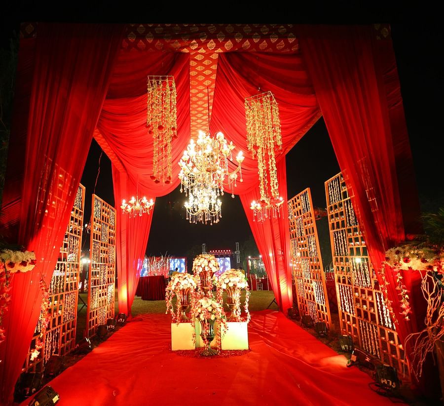 a wedding venue decked up with red cloth and chandelier in the backdrop of the night