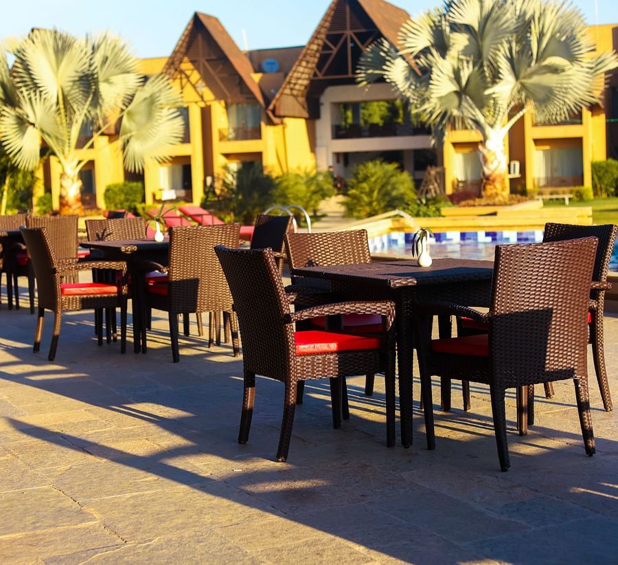 outdoor sitting area with tables and chairs by the pool at Jagira Ananta Elite