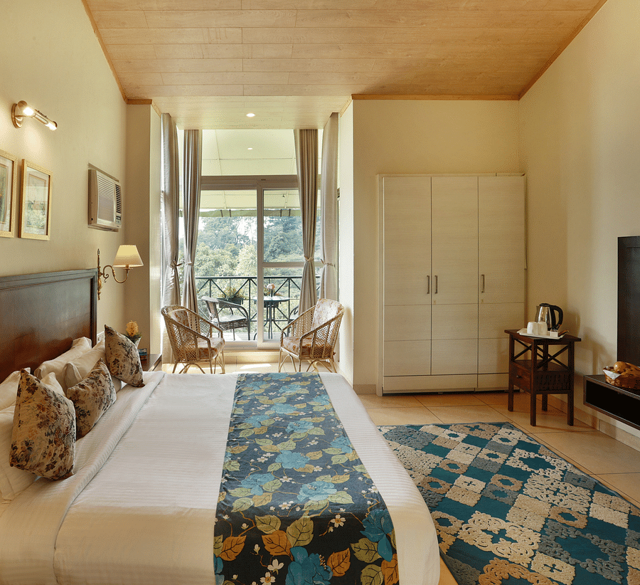 Full angle view of Super deluxe room featuring a balcony overlooking the tea gardens and other room amenities like a television, a tea & coffee maker, among others - Lamrin Norwood Green, Palampur2