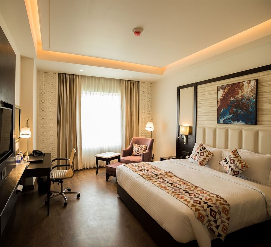 alt-text suite room at Ramada by Wyndham Kapurthala featuring a bed, work desk and a television 2