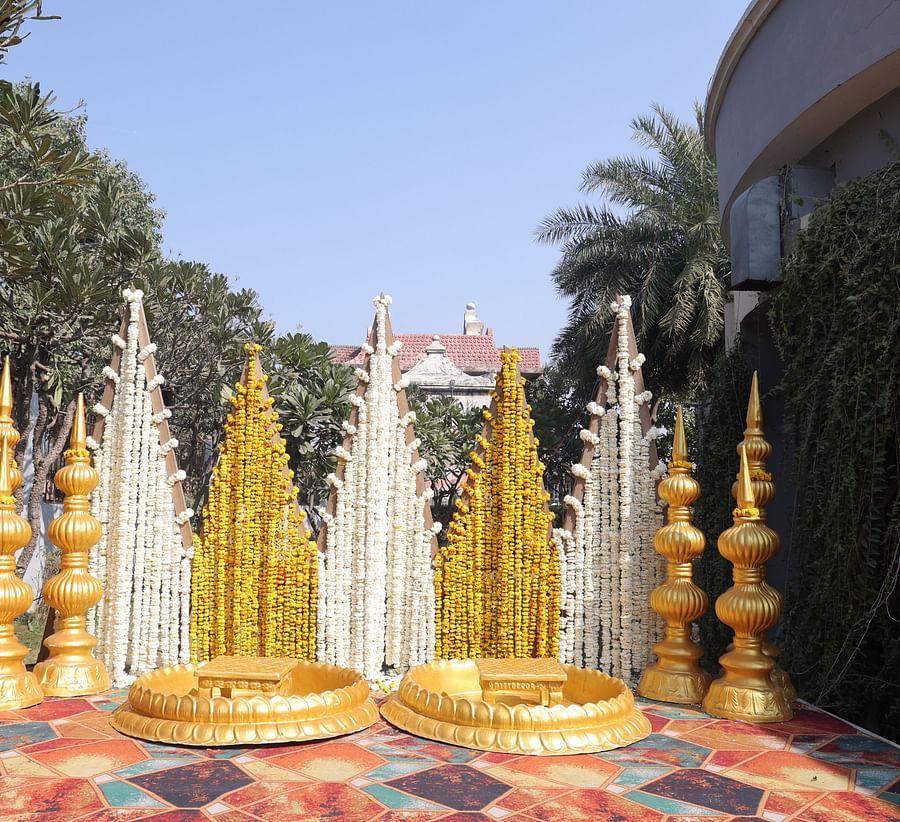 alt-text Traditional wedding stage decorated with golden and marigold accents at Shri Radha Brij Vasundhara Resort & Spa.