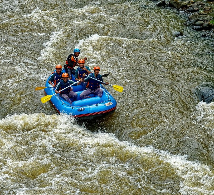 alt-text Aerial view of river rafting on a flowing river, showcasing the excitement of adventure amidst the natural landscape.