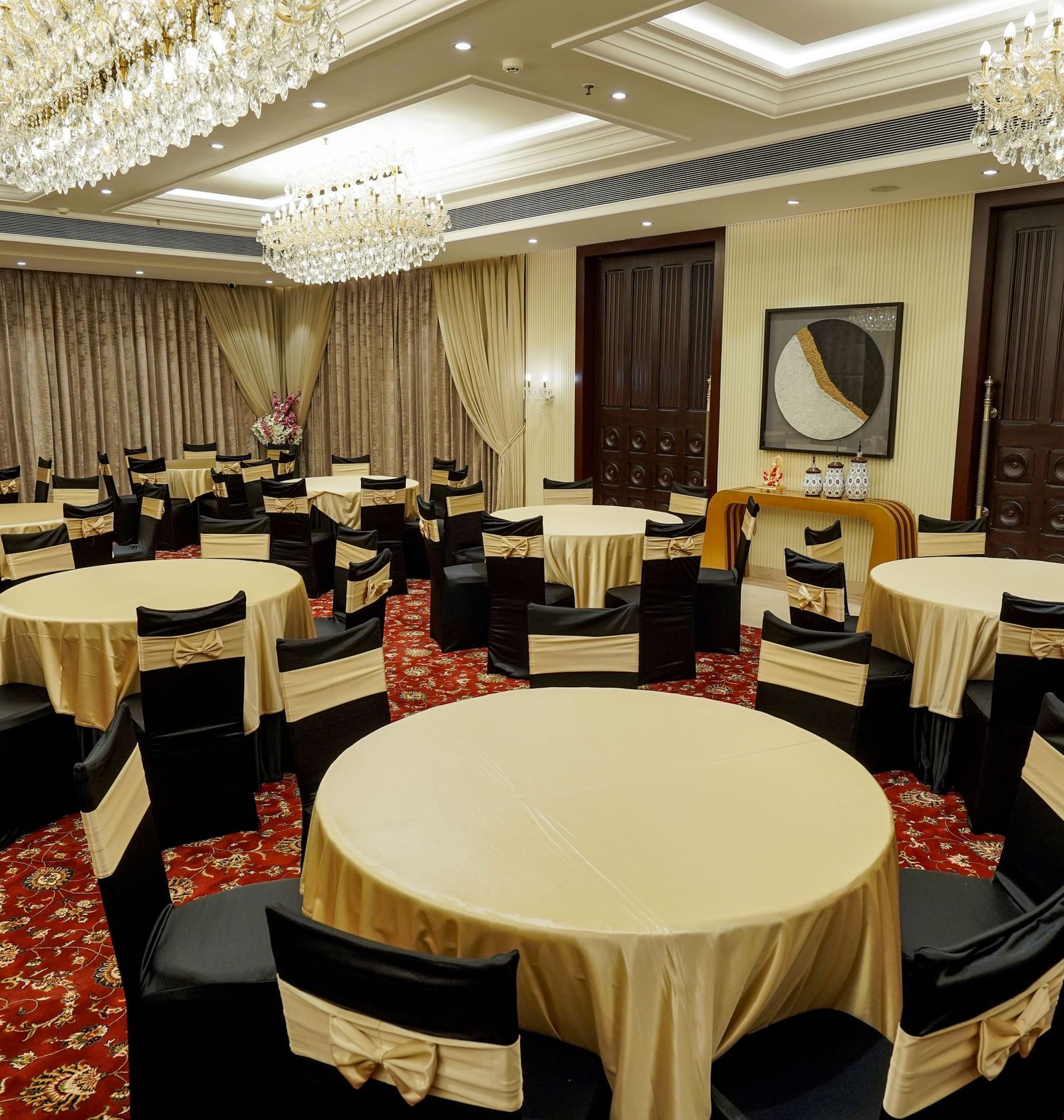 A full view shot of the Ballroom at M2 Square by Monday Premium with various round tables with golden table cloth spread over them.