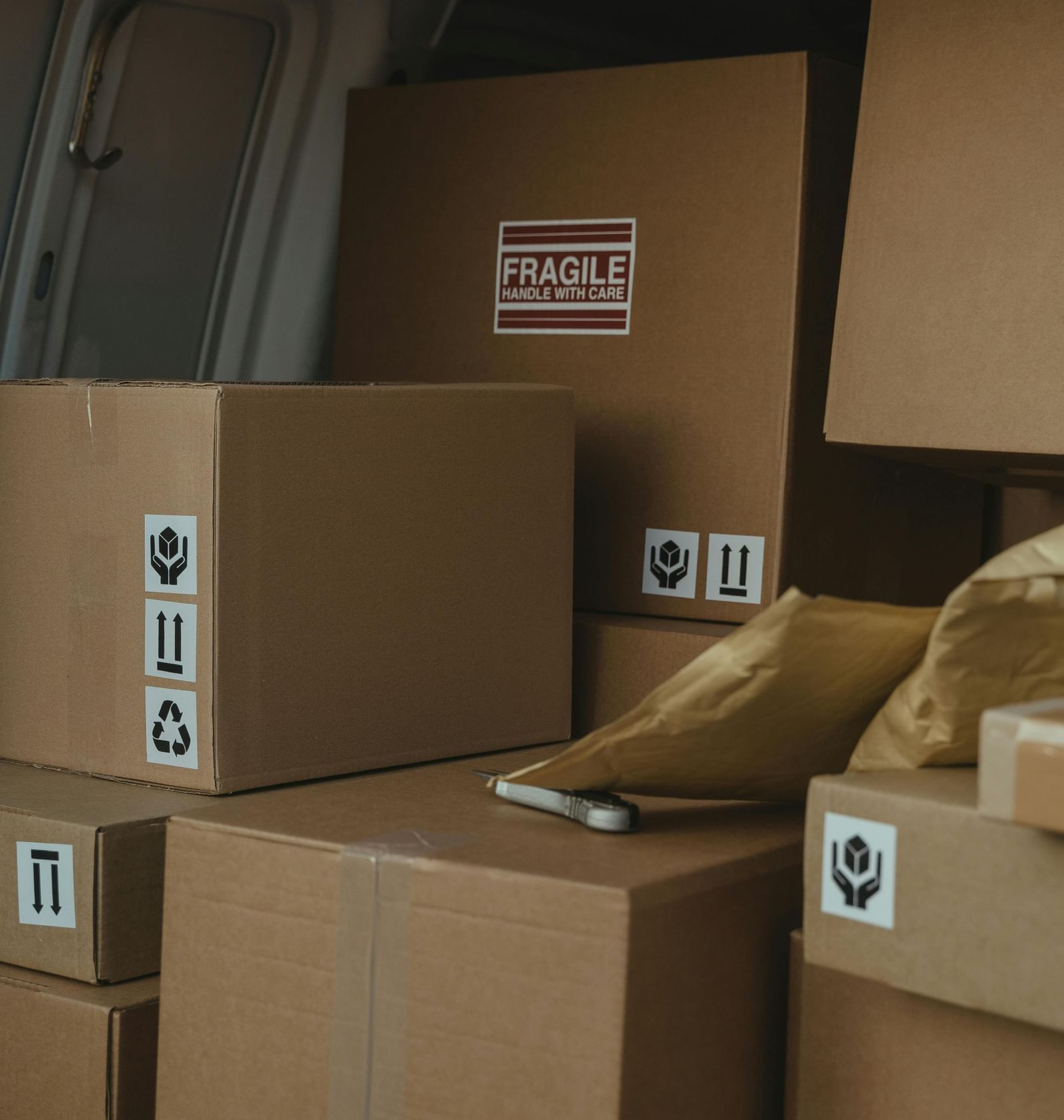 Cardboard boxes stocked up in the back of a vehicle.