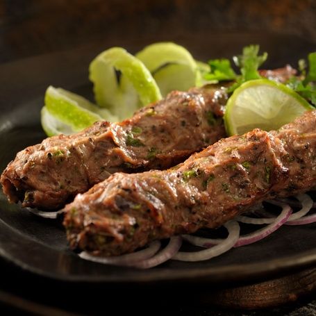Persian Saffron Chicken Kebab with lime and onion rings.